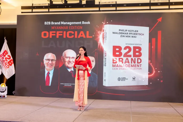 The host on stage beside the B2B Brand Management Myanmar Edition launch screen
