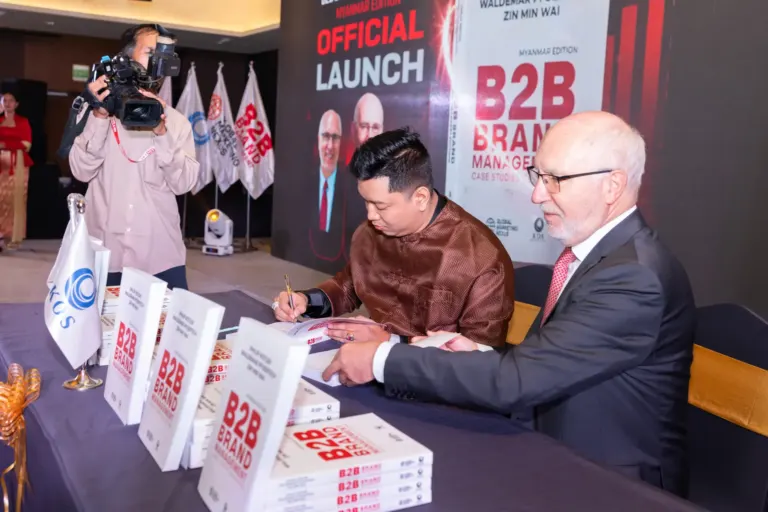 Prof. Zin Min Wai and Prof. Dr. Waldemar Pfoertsch signing copies of the book